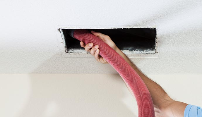 Worker cleaning air duct
