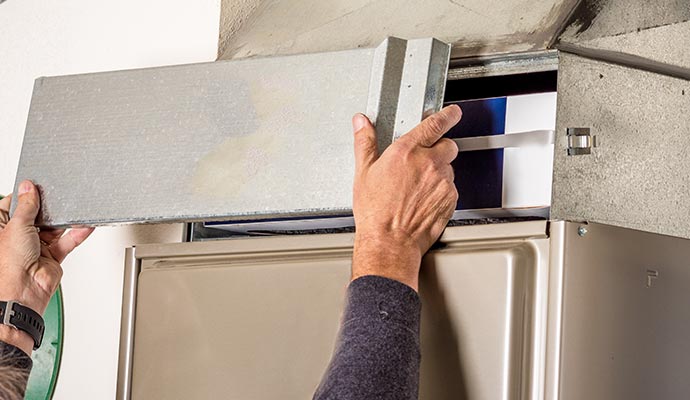 a professional replacing a furnace filter