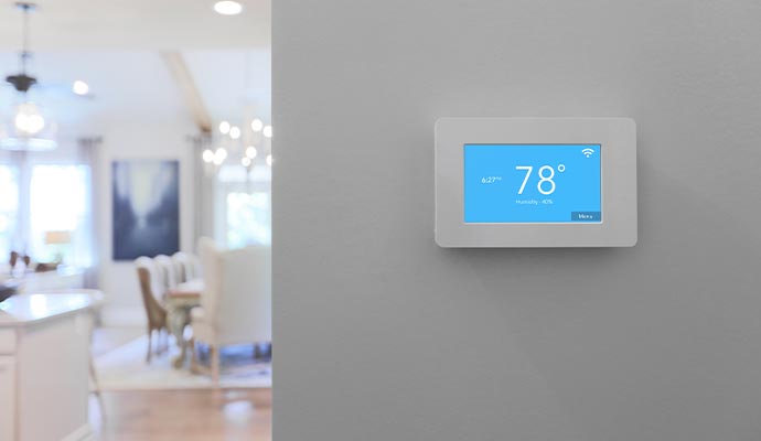 A smart thermostat mounted on a wall in a home for temperature control and energy efficiency.