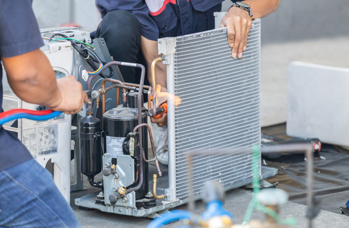 Skilled HVAC technicians fixing a heating pump for efficient and cozy indoor warmth